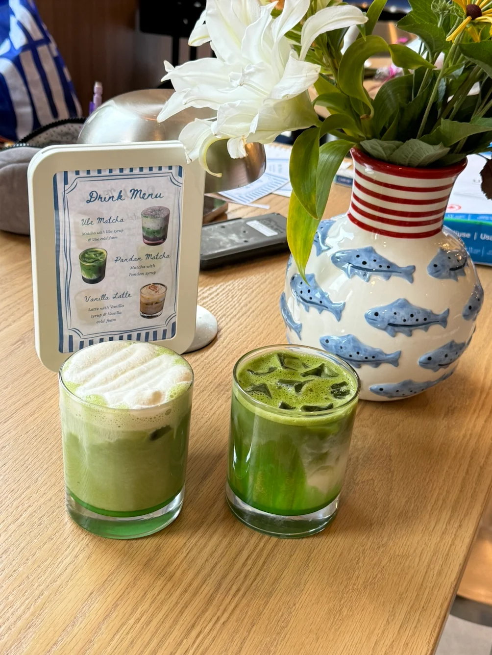 two cups of matcha in front of fish vase